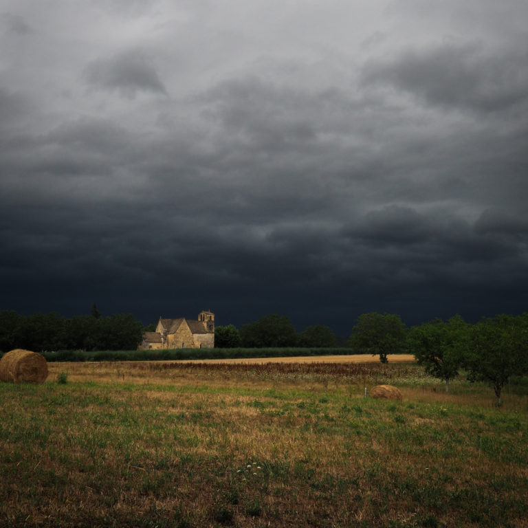 Aménagement jardin Vezac. Ciel orageux sur l'église de Vézac en Périgord Noir