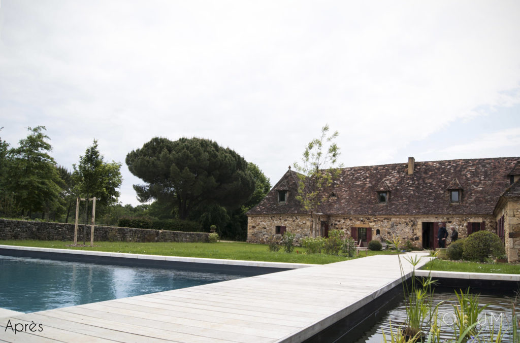 Piscine avec terrasse en bois et bassin d'ornement au coeur d'un jardin du Périgord dessiné par Otium paysage